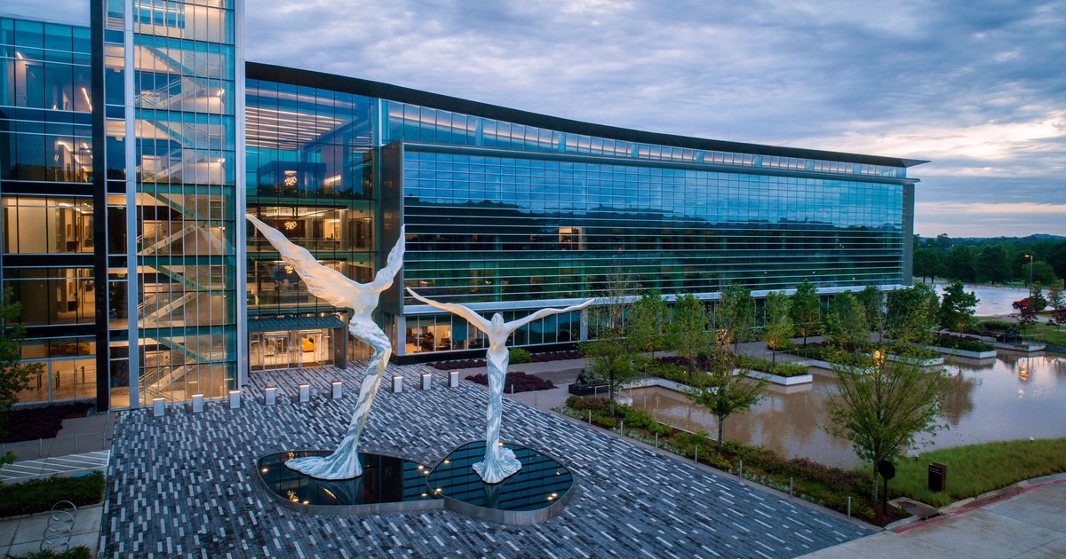 Bank OZK's glass headquarters building in Little Rock with two white winged sculptures in the front plaza