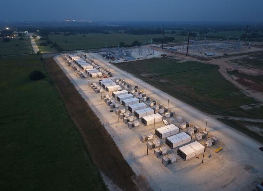 Aerial photo at dusk of rows of battery containers at an example storage plant