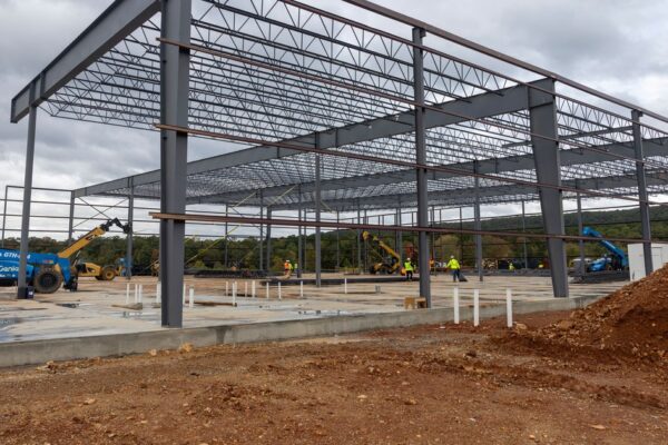 Steel frame of the new Mountain Valley Spring Water bottling plant under construction north of Hot Springs, Arkansas, with construction equipment and workers on the slab