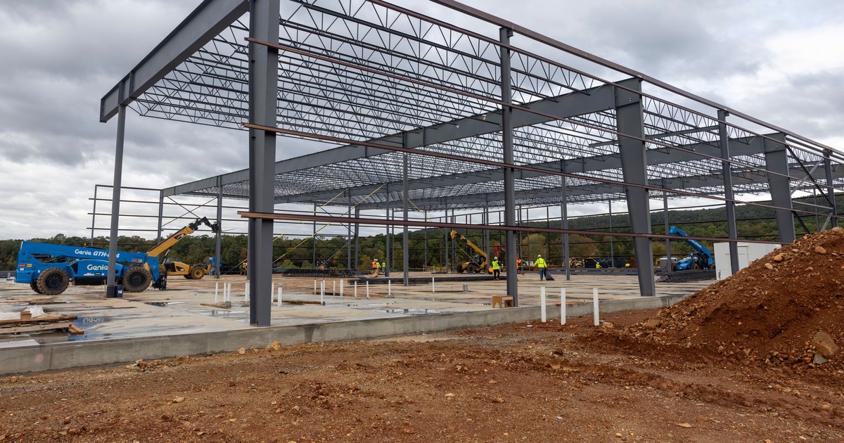 Steel frame of the new Mountain Valley Spring Water bottling plant under construction north of Hot Springs, Arkansas, with construction equipment and workers on the slab