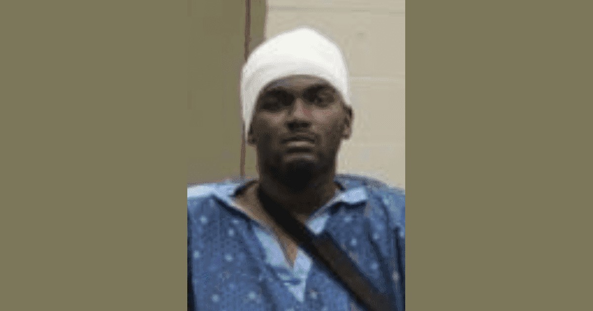 Booking photo of Samuel Lamar Shelton wearing a hospital gown and a head bandage